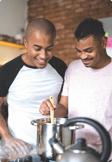 2 men cooking in the kitchen.